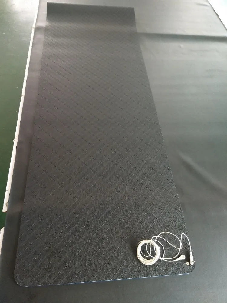 Blue conductive yoga mat with plant pattern, grounding wire, and non-slip surface, rolled partially.