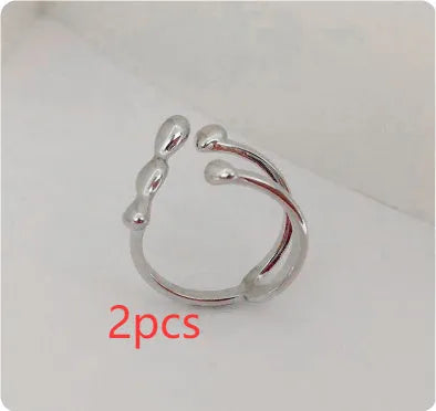 Gold adjustable open ring with spherical details on a woman's hand, showing the 1cm gap.