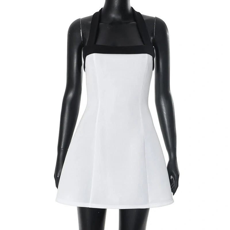 Elegant black and white mini dress with halter neckline, sleeveless design, and short skirt length