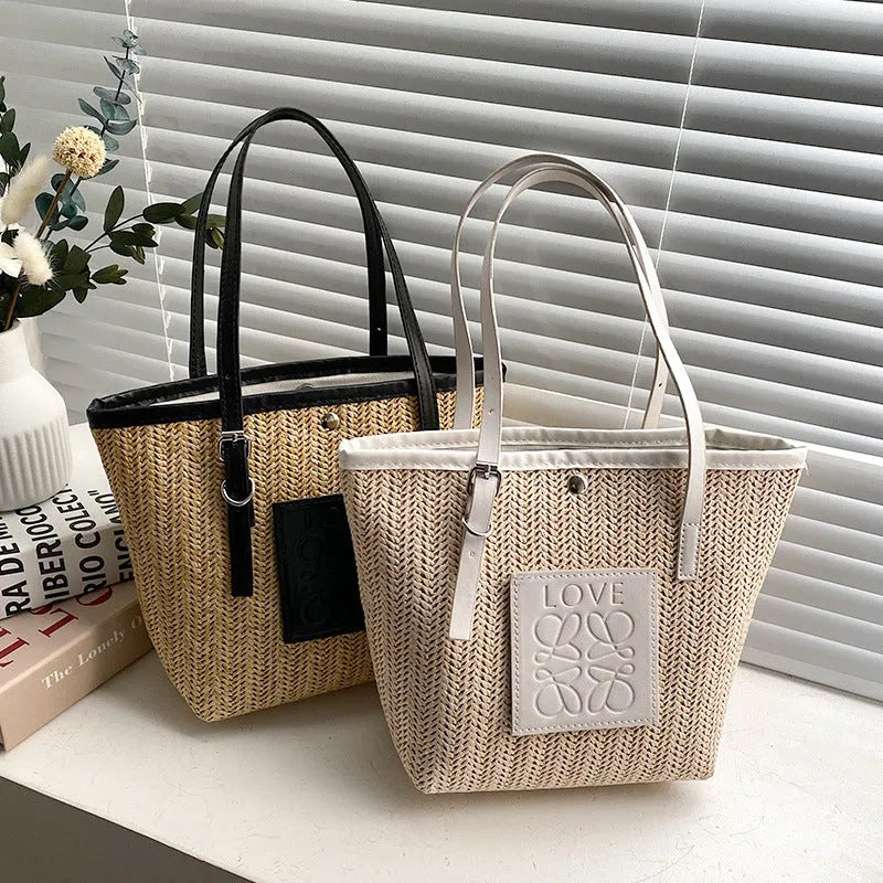 White woven straw women's shoulder bag with a three-dimensional pocket and a black handle.