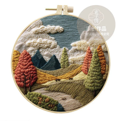 Complete DIY embroidery kit with 15cm bamboo frame, pre-printed landscape fabric, threads, and needles laid out.