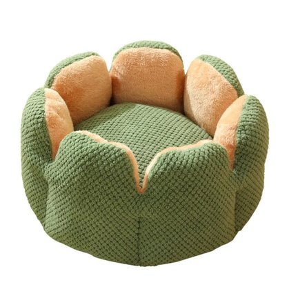 Green petal cactus-shaped plush cat bed with a cave-like opening on a wooden floor
