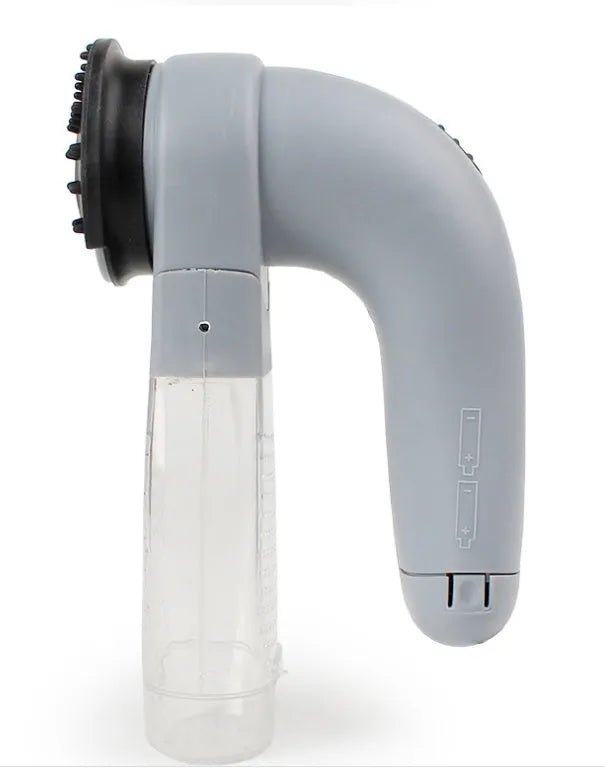 Grey handheld electric pet hair remover brush with soft rubber head for grooming dogs and cats.