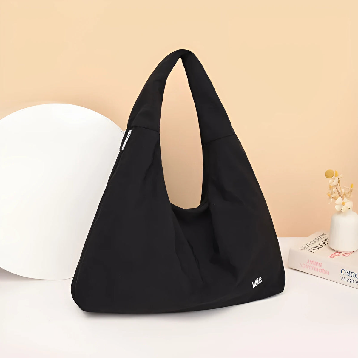 A soft nylon underarm bag with a heart-shaped design in blue, shown worn crossbody.