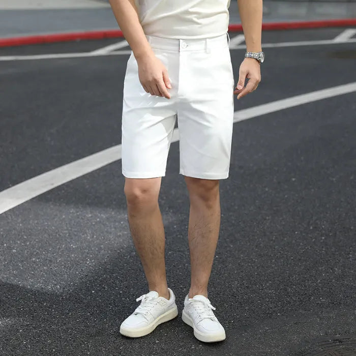 Man wearing loose-fit beige fifth pants with an elastic waistband, showcasing the mid-length casual style.