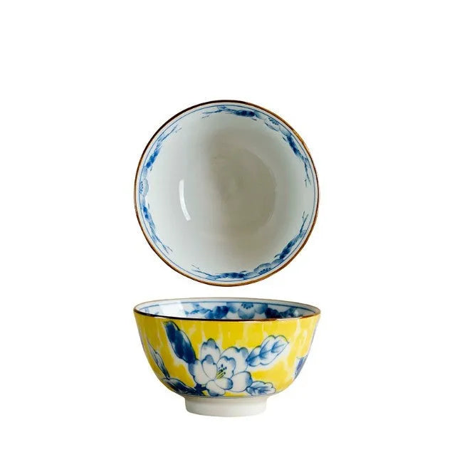 Yellow ceramic tableware set with colourful floral patterns, includes bowls and plates in Japanese style