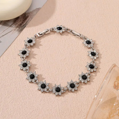Gold and silver electroplated bracelets with flower charms set with coloured gemstones.