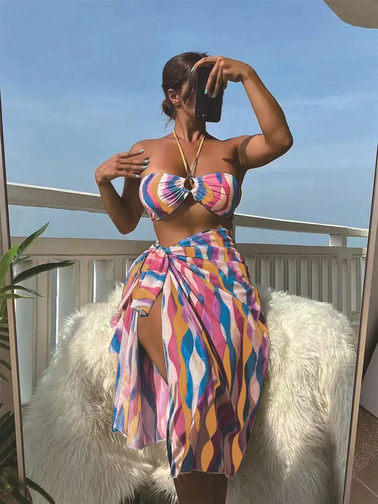 Women's three-piece swimwear set showing bikini top, briefs and printed beach skirt in polyester fabric