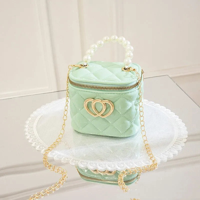 White PVC women's bucket bag with a heart-shaped pattern and shoulder strap.