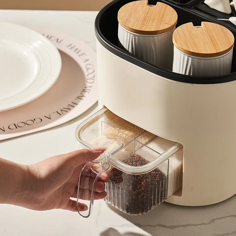 White rotating plastic kitchen storage bucket and a separate white spice box with four compartments on a countertop.