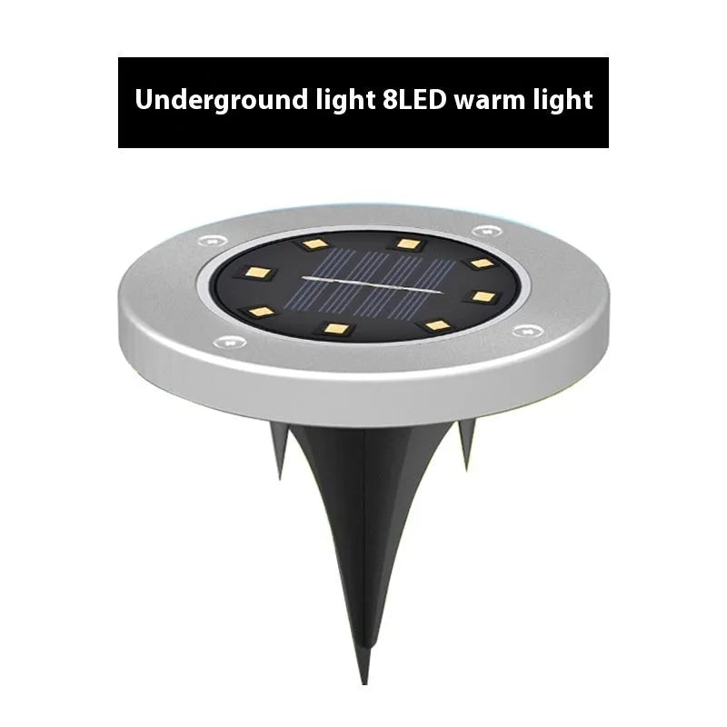 Stainless steel solar garden ground lamp installed in a lawn.