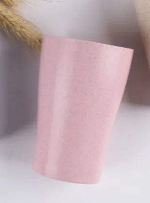 A cylindrical wheat straw plastic bathroom cup in a Nordic colour, holding toothbrushes.
