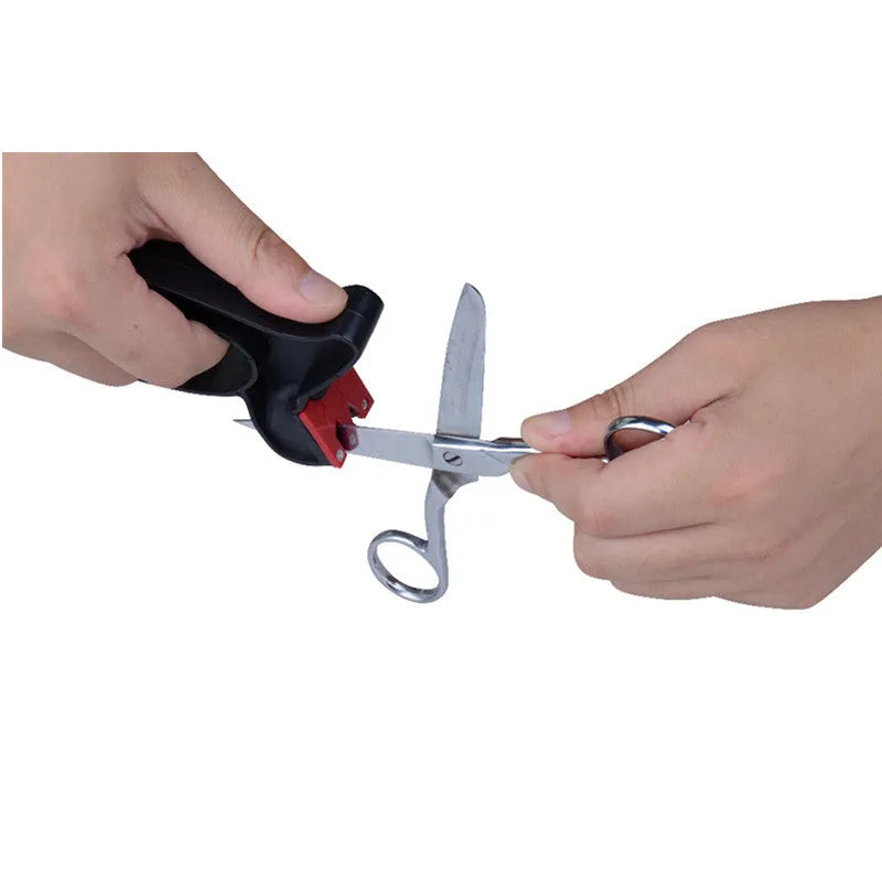Black handheld knife and scissor sharpener with ergonomic grip, showing tungsten steel grindstone slot.
