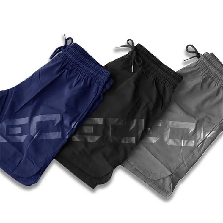 Man wearing black knee-length nylon training shorts with an elastic mid waist.
