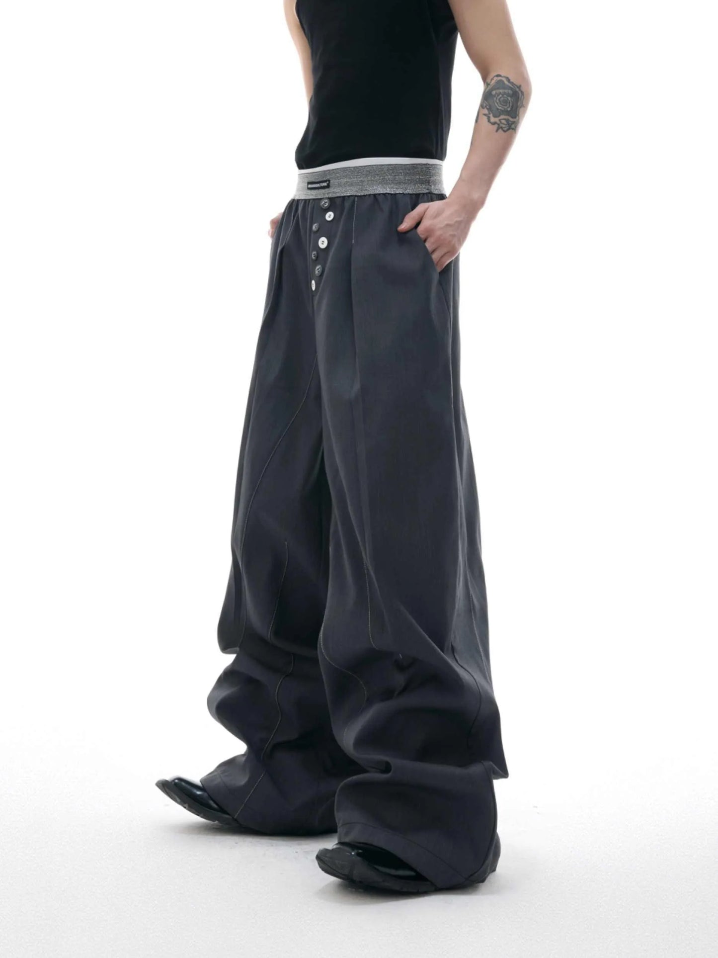 Straight-leg trousers with button-open line detail in black and grey colours, showing high-waist design and tailored silhouette