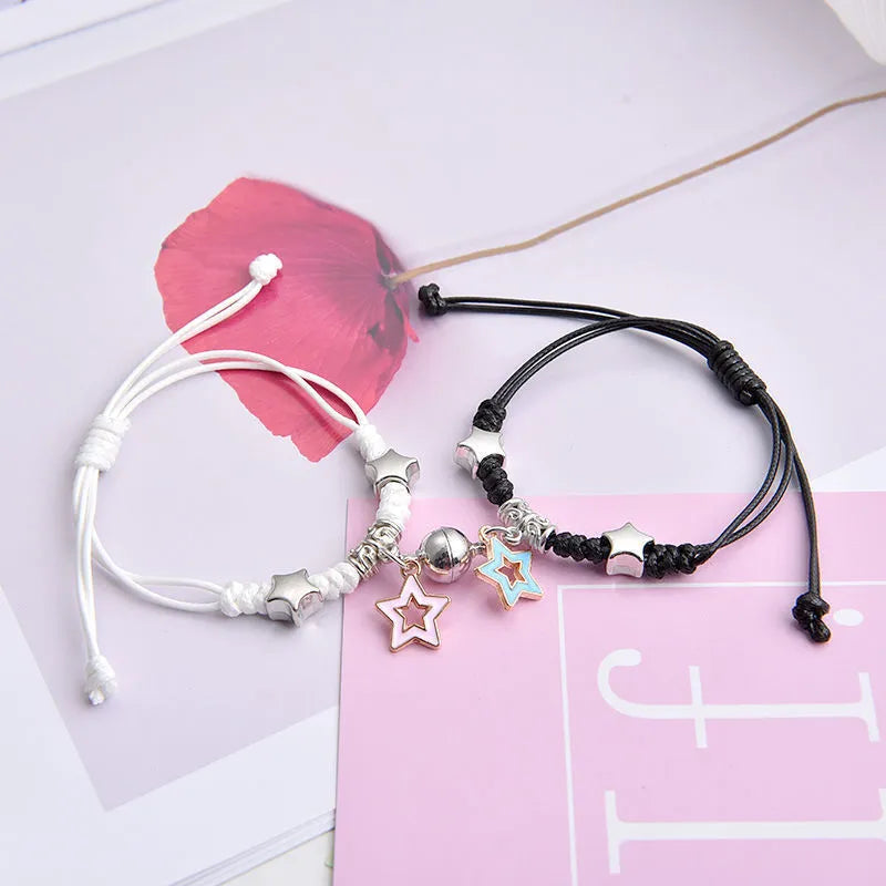 A pair of magnet couple bracelets with a suction clasp, showing various design options like clovers, crowns, and hearts.