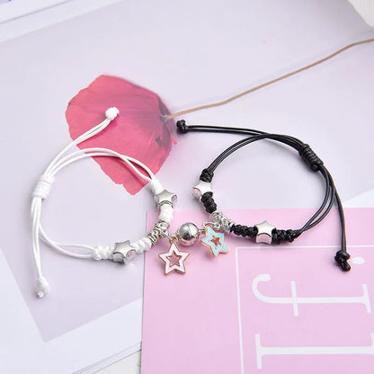 A pair of magnet couple bracelets with a suction clasp, showing various design options like clovers, crowns, and hearts.