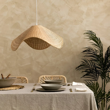 Handmade woven rattan and willow chandelier with warm LED light in a rustic setting.