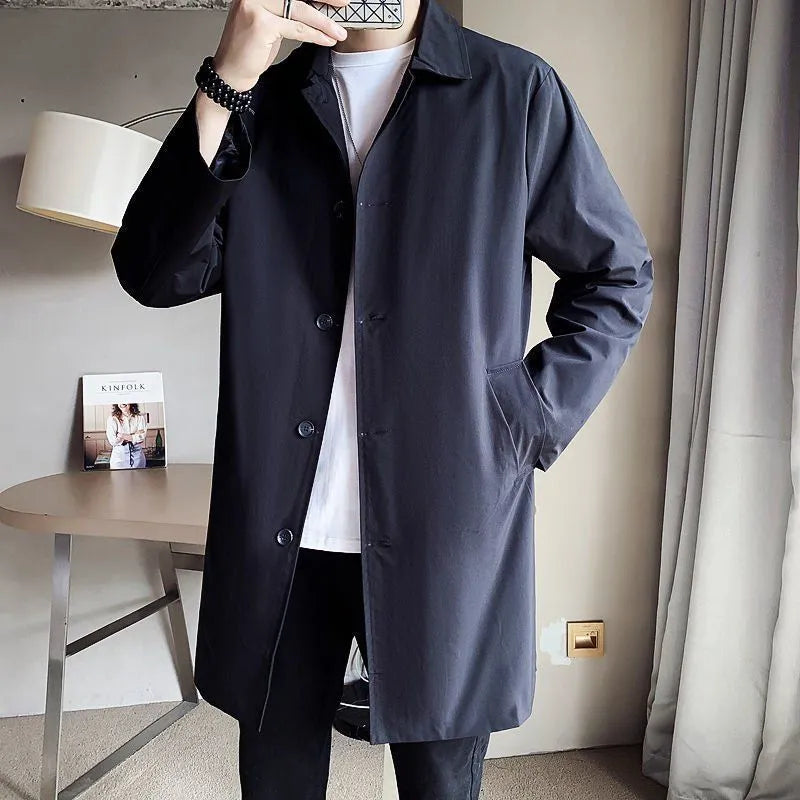 Man wearing a khaki coloured loose fit mid-length trench coat made from rabbit fur fabric.