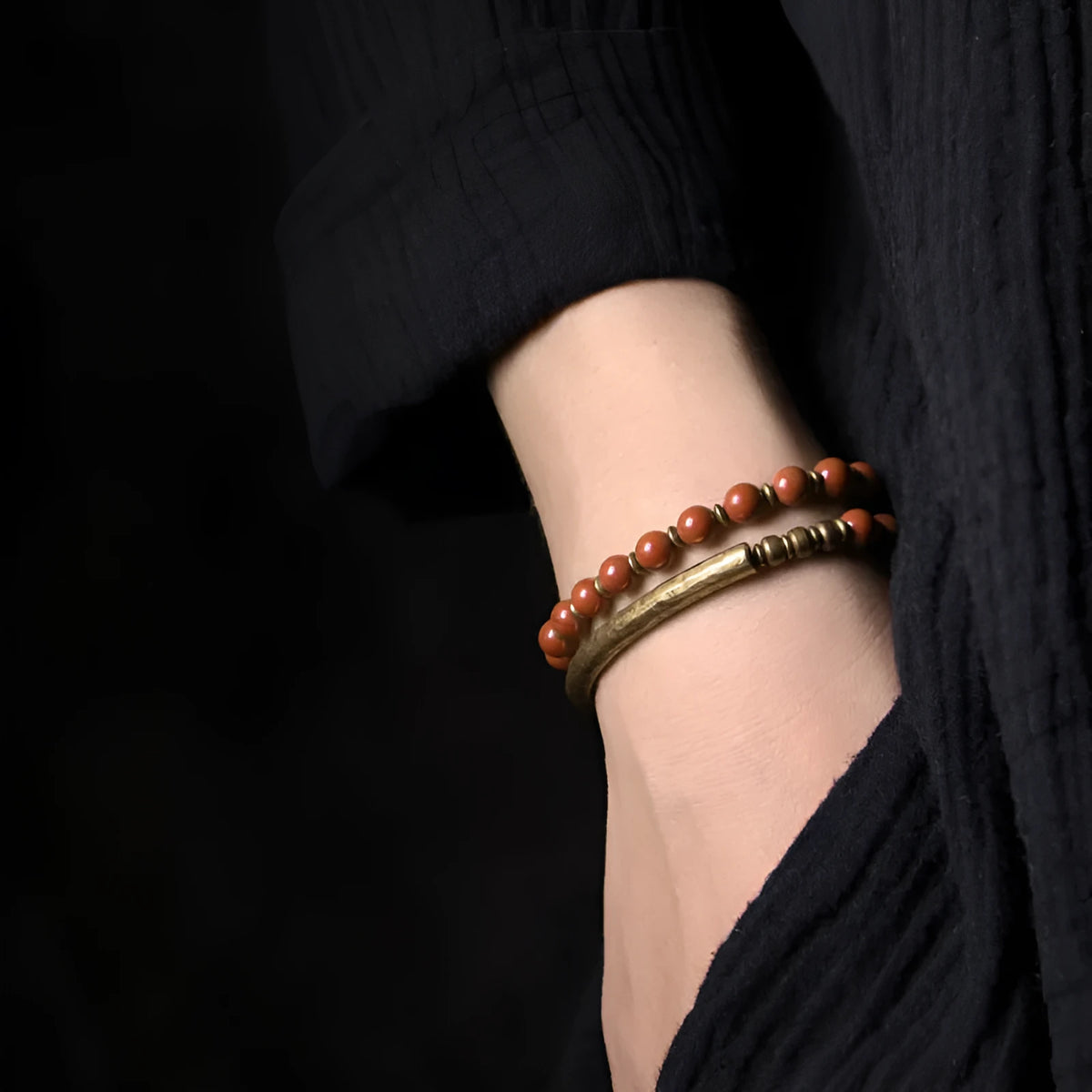 Layered stone and brass ethnic bracelet for men and women on a wrist.