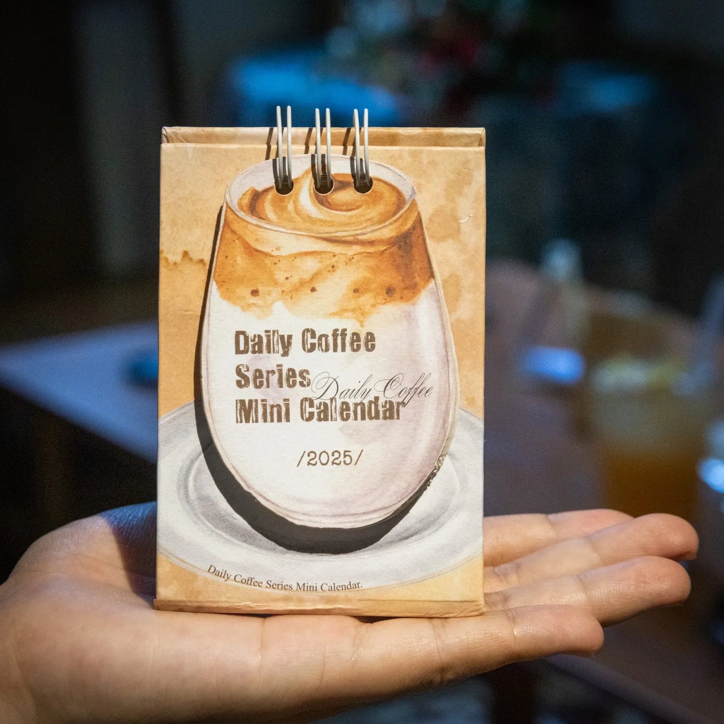 Set of four different themed 2025 mini paper desk calendars on a desk.