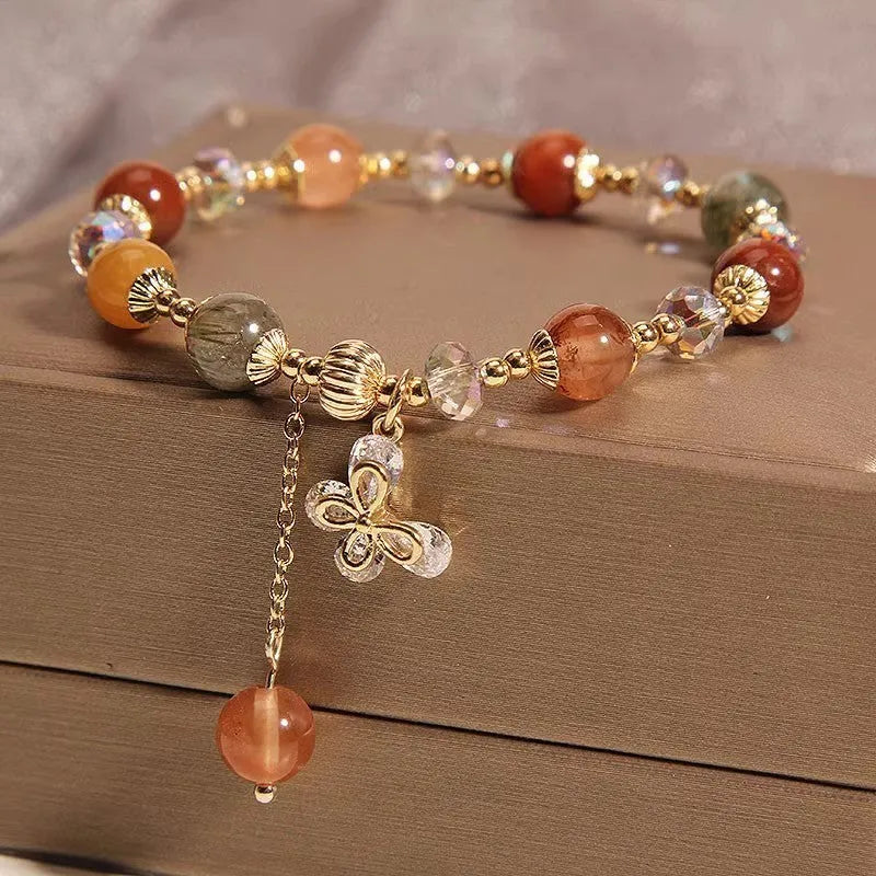 Colourful hair crystal stretch bracelet with cat's paw, butterfly, flower, and purse charms on adjustable band