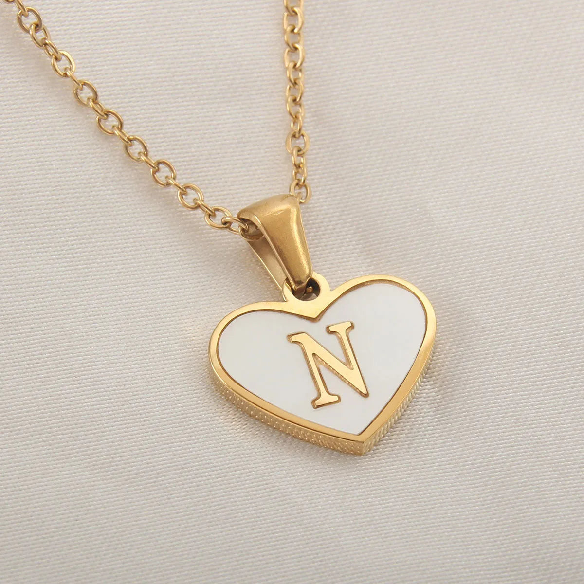 Gold-plated heart necklace with white shell pendant showing letter personalisation option