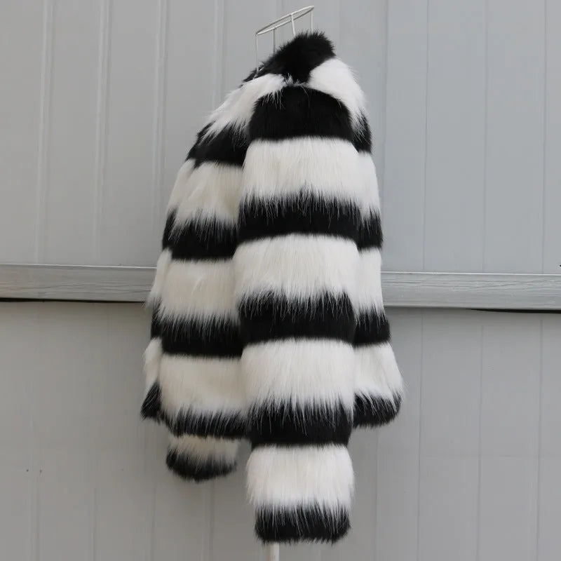 Womens black and white striped long-sleeved faux fur leather jacket on a hanger.