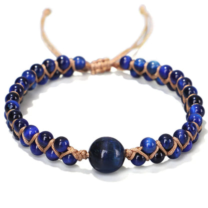 Close-up of a hand-woven geometric bracelet with a blue Tigereye stone on a wrist.