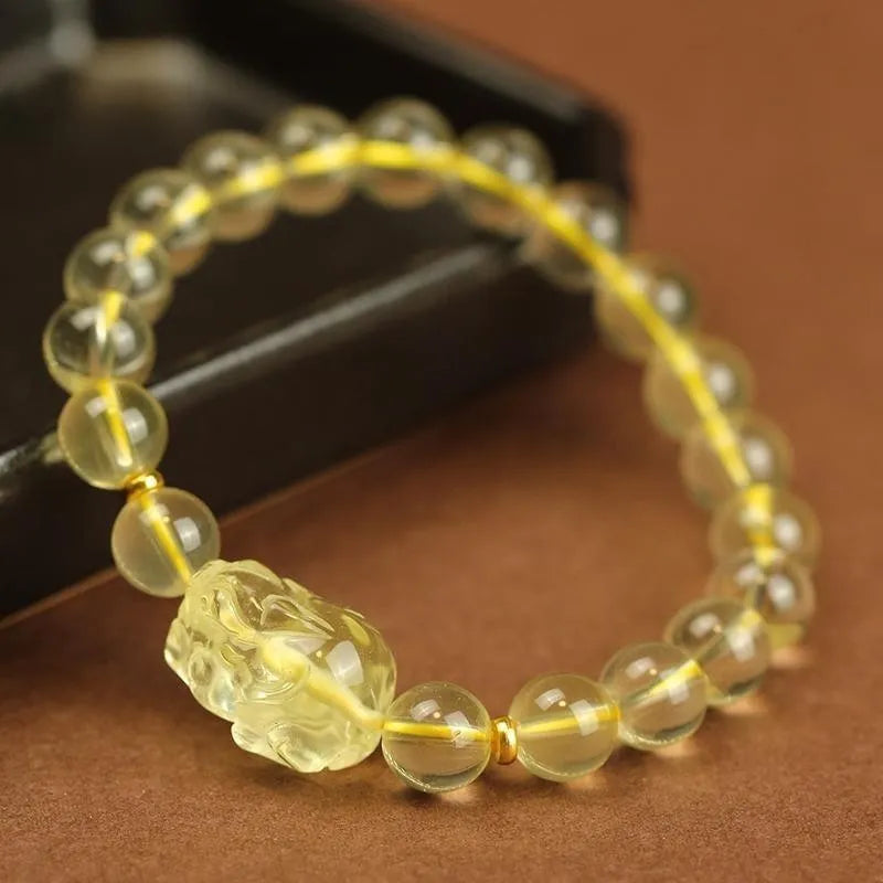Yellow artificial crystal Pi Xiu charm on a leather bracelet, shown with different bead size options.