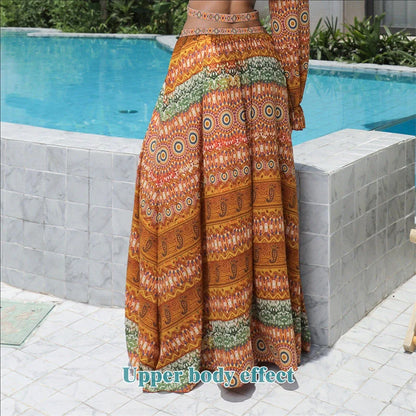 Elegant floral print dress with long sleeves and empire waistline in vibrant orange color