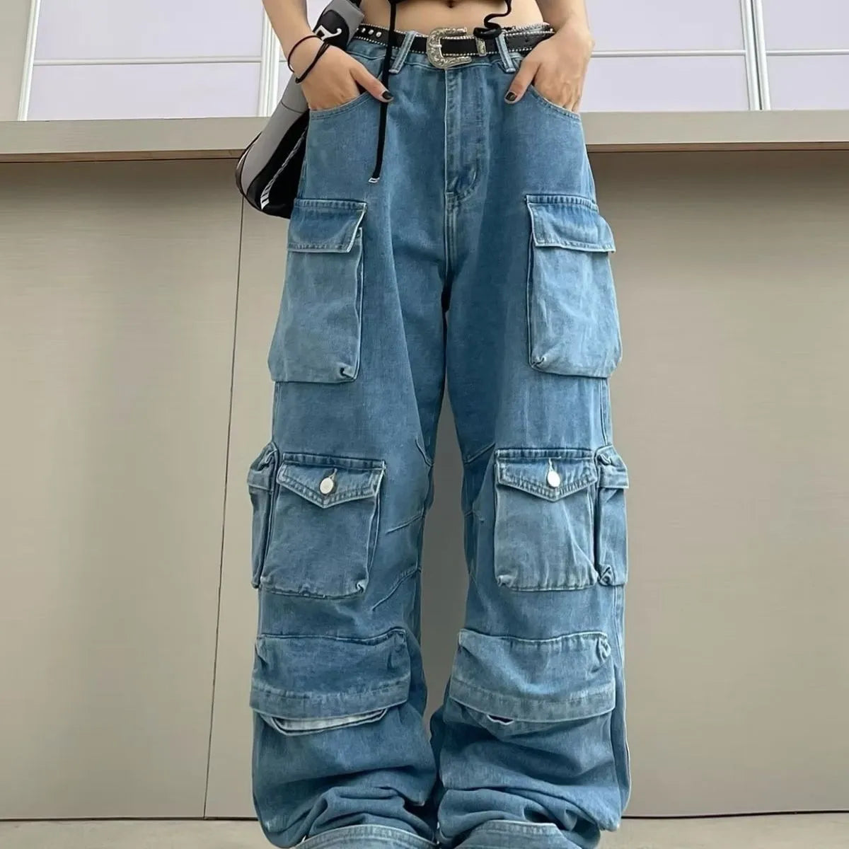 Blue high waist wide leg denim trousers with multiple pockets on a mannequin