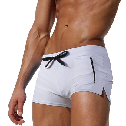 Men's black high-waisted swimming trunks with a lace-up front closure, shown on a model.