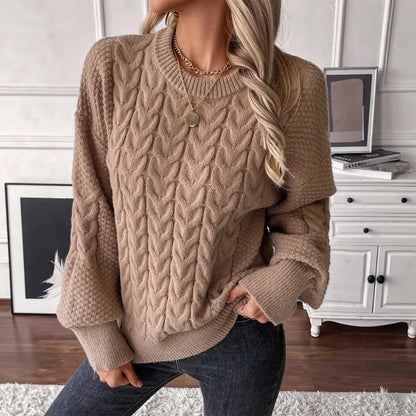 Women's beige twist knit loose sweater with round neck and regular sleeves on a hanger