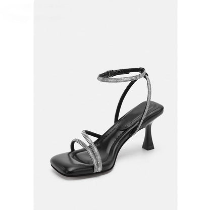 Women's silver rhinestone sandals with square toe and ankle strap buckle on a white background.