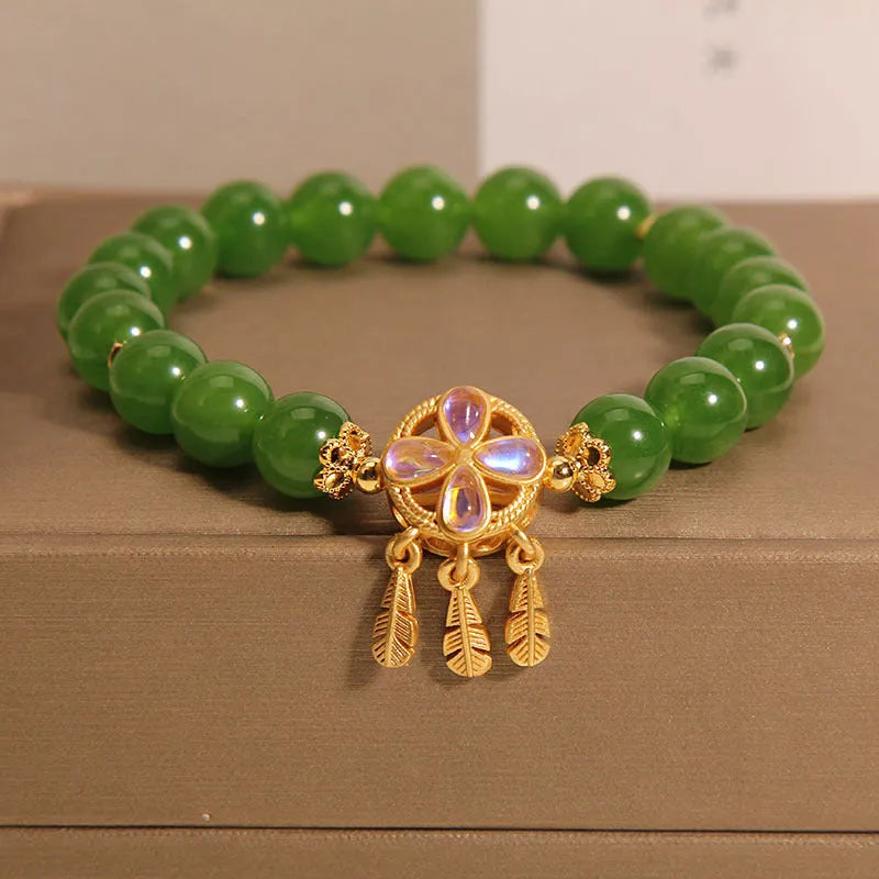 Green jasper crystal four-leaf clover dream catcher pendant on a women's bracelet.