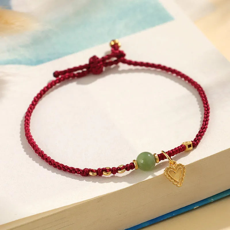 Handmade women's bracelet with 925 silver and Hetian jade in woven design with red carrying strap