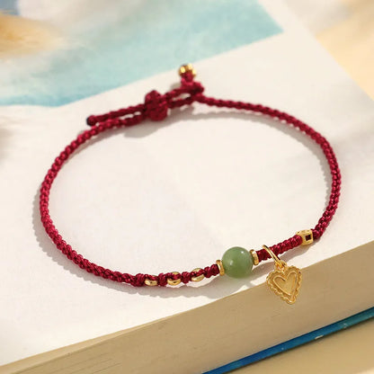 Handmade women's bracelet with 925 silver and Hetian jade in woven design with red carrying strap