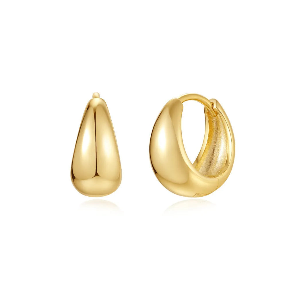 Pair of golden geometric clip-on earrings with a round design and screw-back mechanism on a white background.