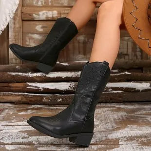 Women's black mid-calf boot with chunky rubber sole and pointed toe on a white background.