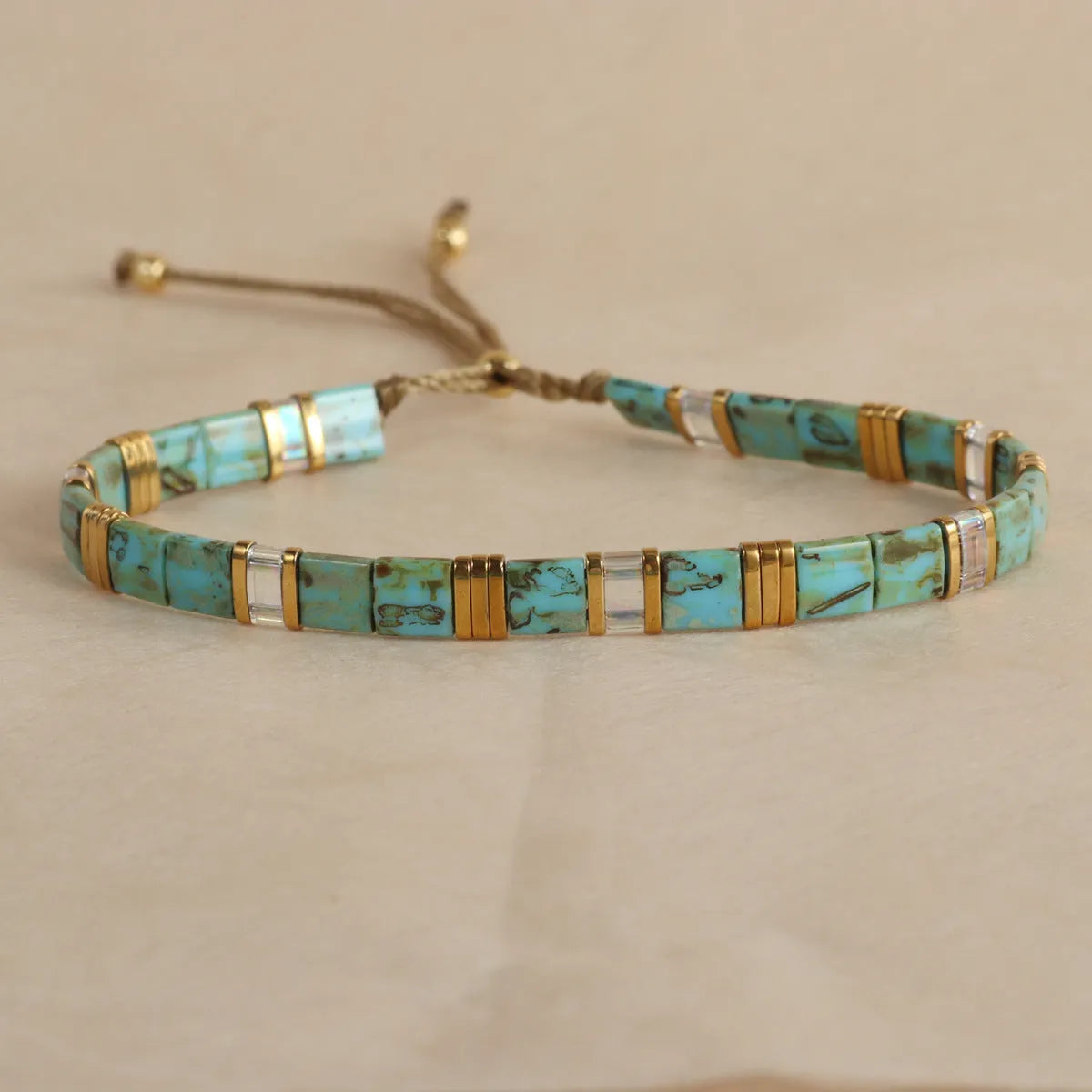 Geometric glass beaded pull bracelet in multiple colours including milky white, black, retro green, light blue, and red