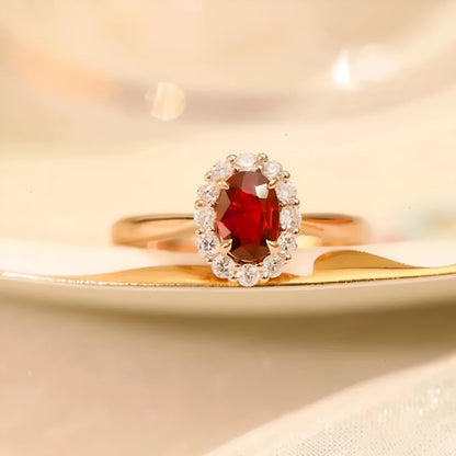 Gold pigeon and floral design women's ring with red gemstone inlay on a silver band.
