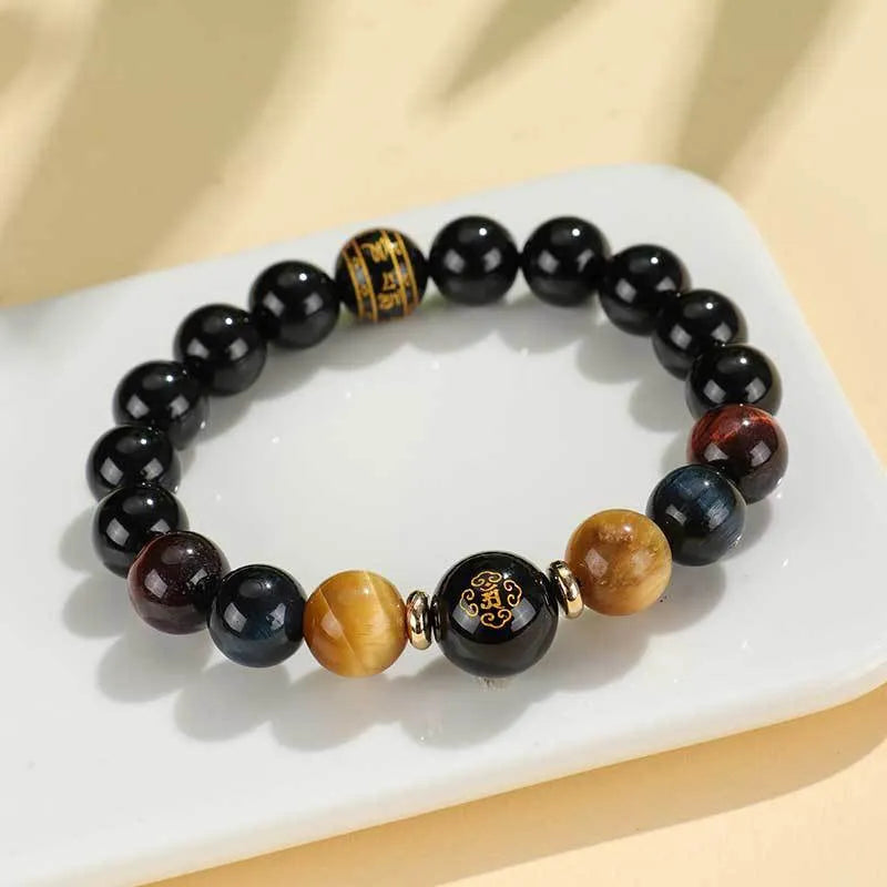 Handcrafted black agate and tiger eye stone beaded bracelet with a central carved zodiac deity charm.