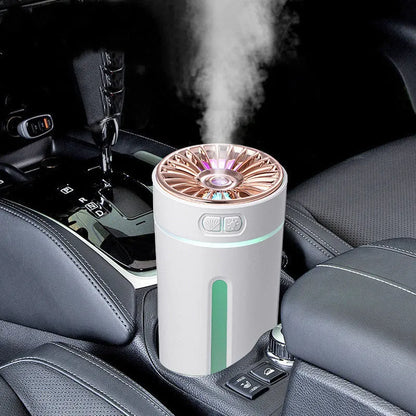 Black portable humidifier with LED lights beside car cup holder showing mist output
