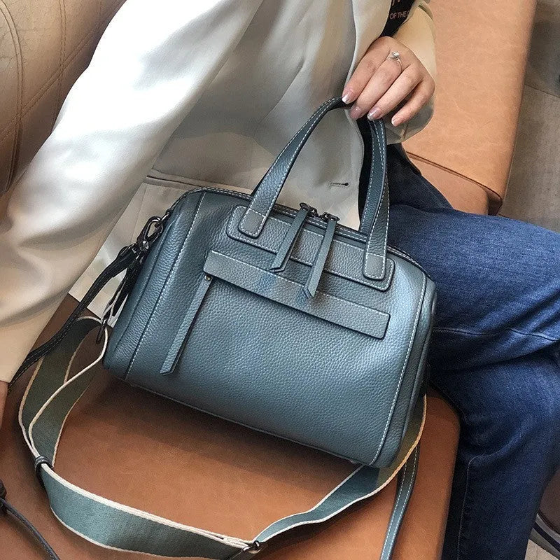 Genuine leather horizontal messenger bag in wine red with shoulder strap and internal zippered compartments.