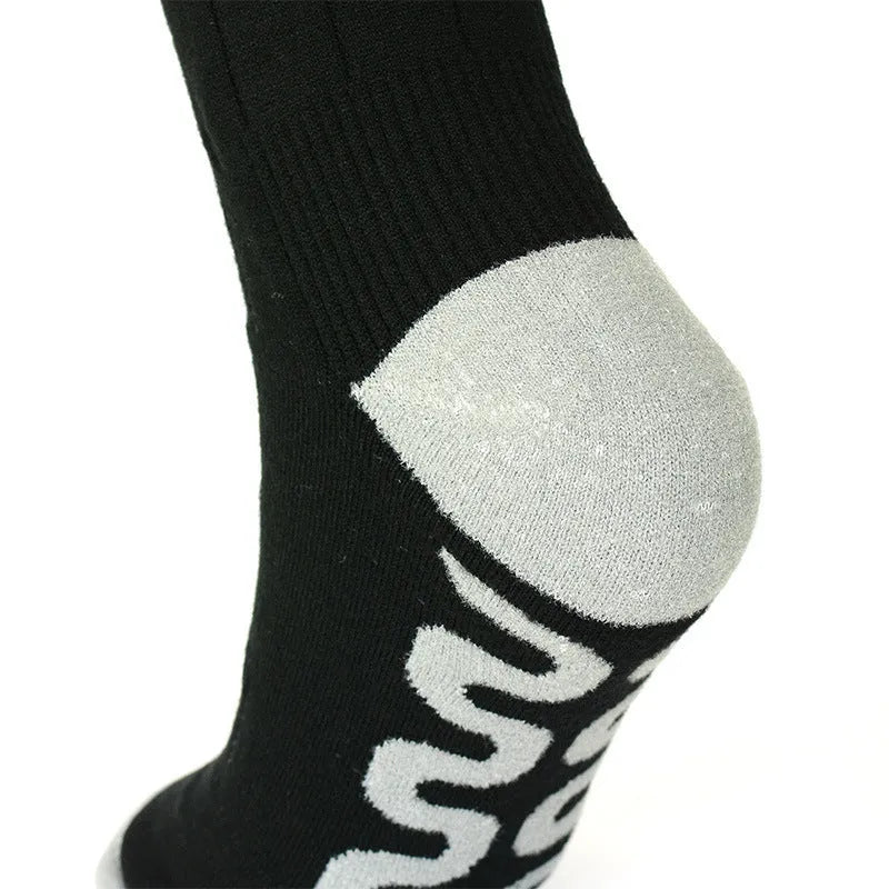 Black and grey mesh smart heating socks with USB cable and battery for skiing.