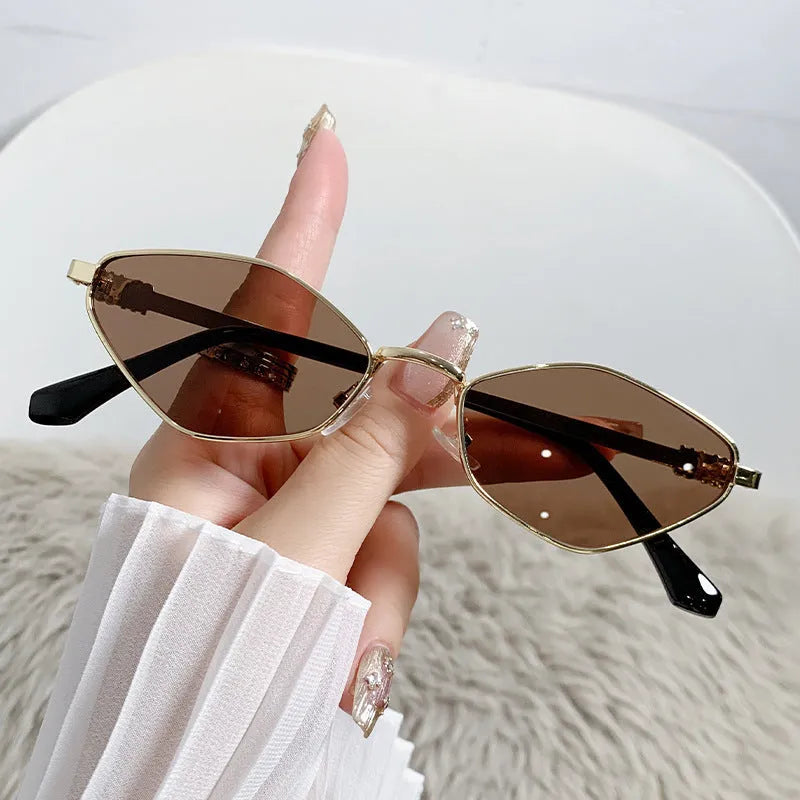 Gold metal frame rhombus-shaped cat eye sunglasses on a neutral background.