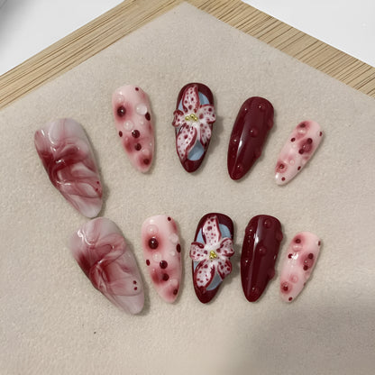 Hand-painted 3D carved nail wraps in Almond colour showing floral and geometric designs for mid-length manicures.