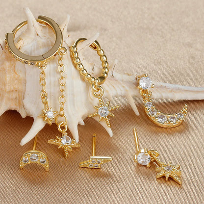 Set of six gold-coloured XINGX chain tassel stud earrings with zircon details on a flat surface.