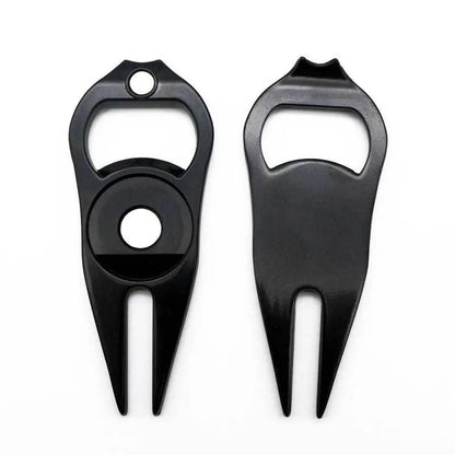 Black zinc alloy golf ball fork and bottle opener tool on a putting green.